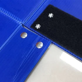 Close-up of blue PP corrugated box panels with metal fasteners and a black strip.